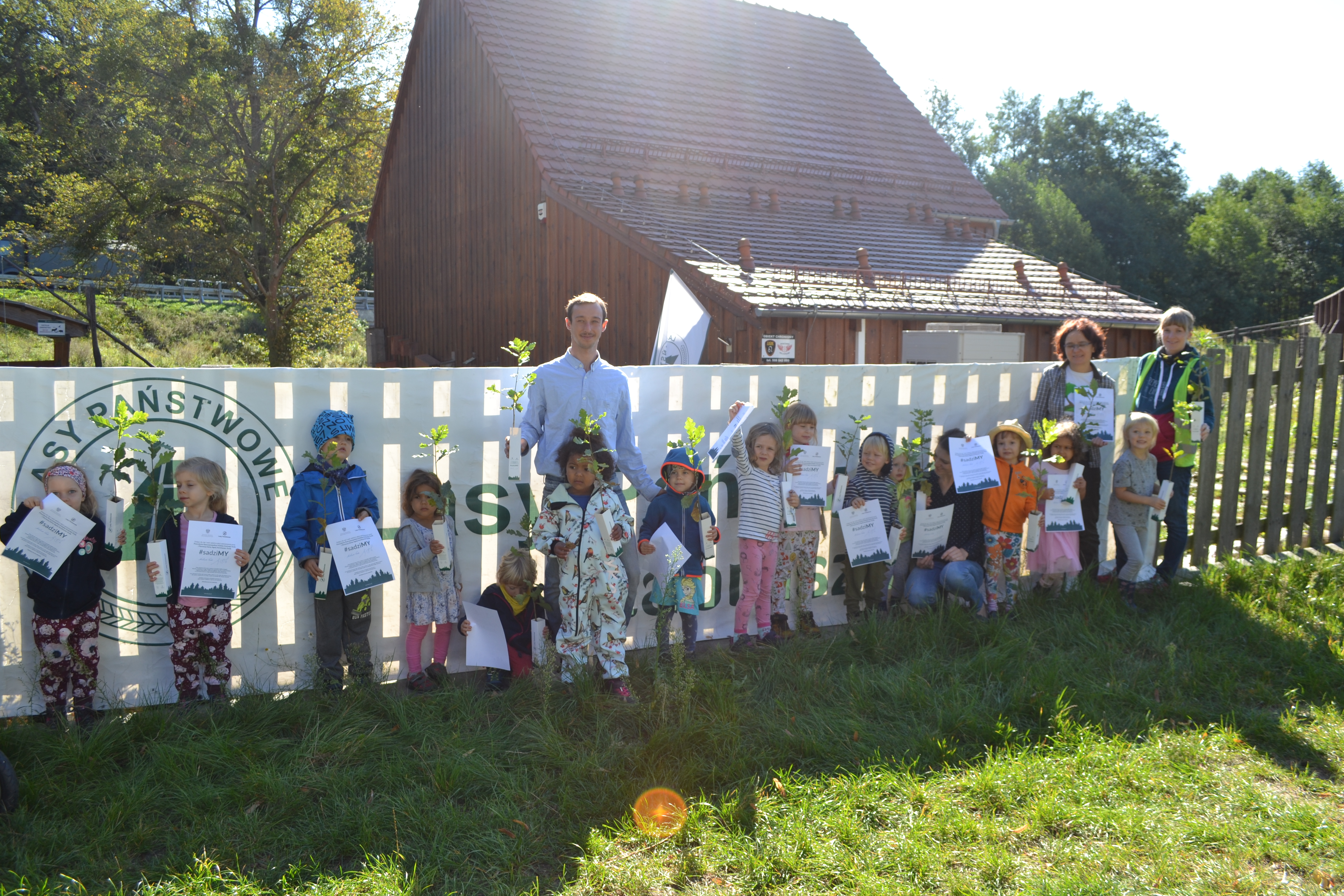 Zdjęcie przedstawia przedszkolaków z „Przedszkola leśnego Leśne Gzubki” w Poznaniu uczestniczących w akcji #sadziMY w OEL „Łysy Młyn”. 