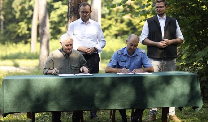 Zdjęcie przedstawia podpisanie porozumienia Lasów Państwowych ze Służbą Więzienną. Dokument podpisują szefowie Służby Więziennej (Jacek Kitliński) i Lasów Państwowych (Józef Kubica) w obecności ministrów Edwarda Siarki i Miechała Wosia. Archiwum DGLP.